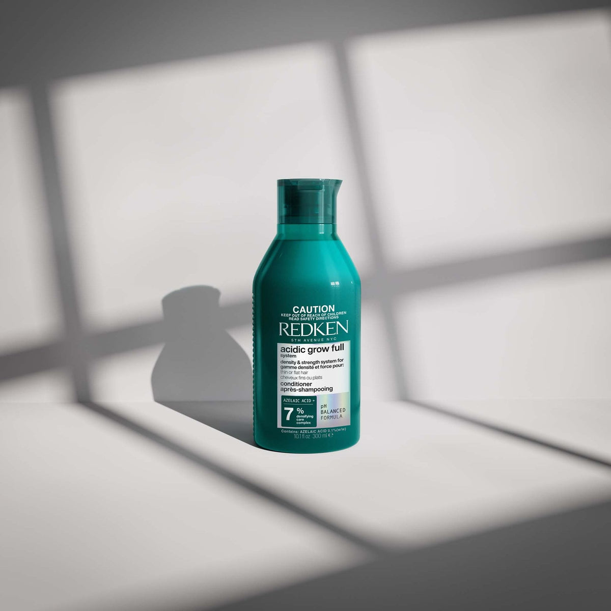 Redken Acidic Grow Full System Densifying Conditioner 300 mL — bottle on a white surface in window light